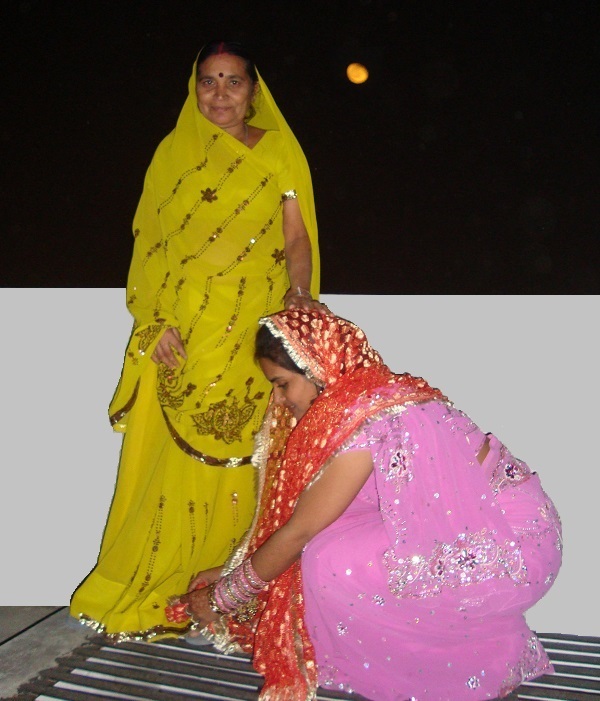 Married woman touching the feet of her mother-in-law to take blessings on Karva Chauth.